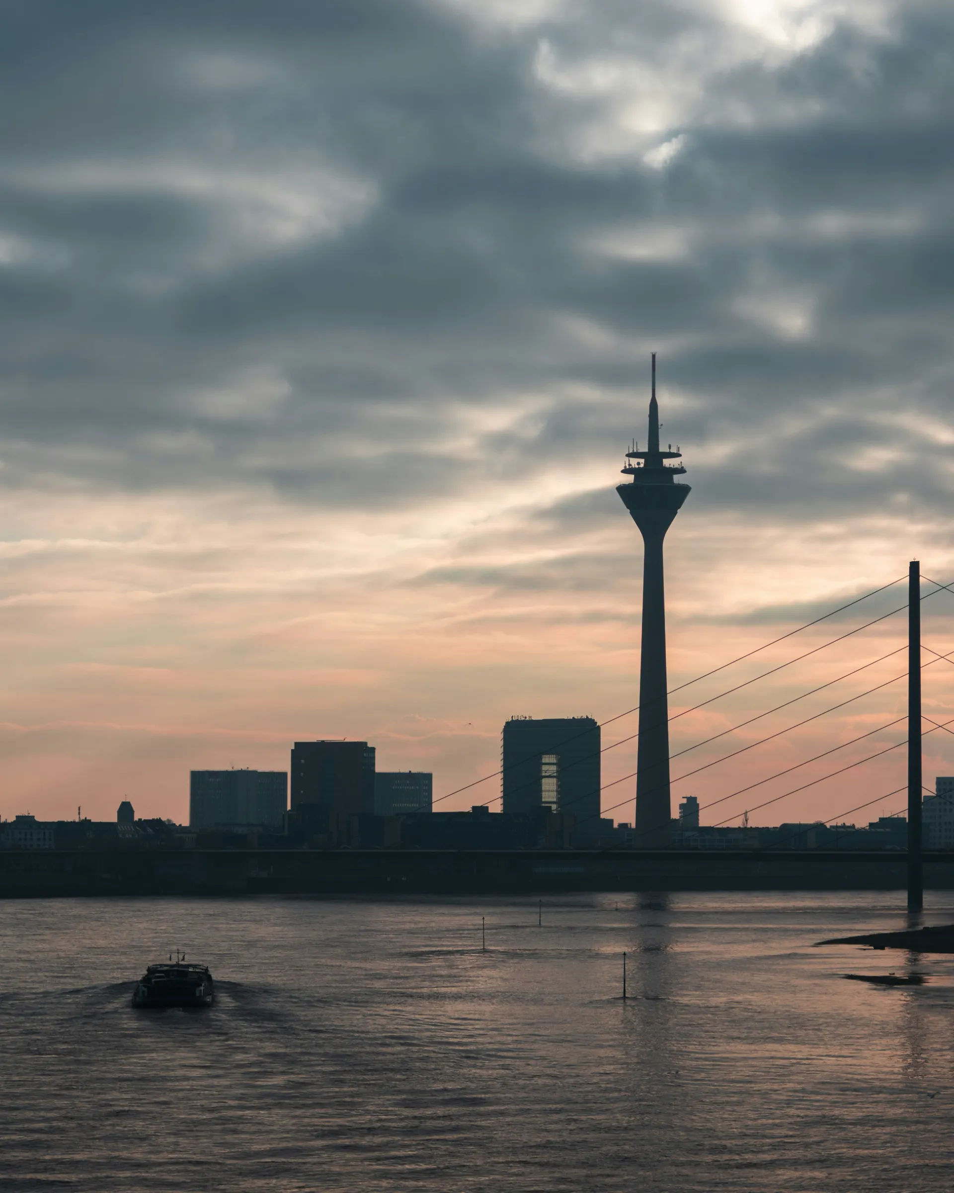 Düsseldorfer Rheinturm und Rhein in der Abenddämmerung
